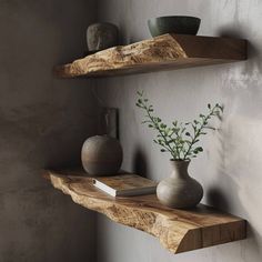 two wooden shelves with vases and books on them next to a wall mounted shelf