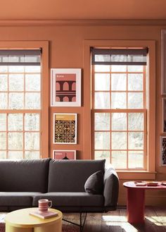 a living room filled with lots of windows next to a gray couch and coffee table