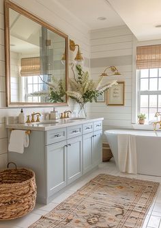 a bathroom with a rug, sink and bathtub next to a large mirror on the wall