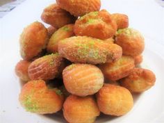 a pile of doughnuts sitting on top of a white plate covered in green sprinkles