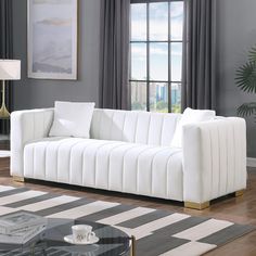 a white couch sitting in front of a window