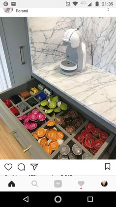 the drawer is open and there are many different items in it on the counter top