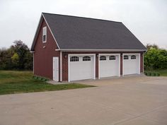 a two car garage with three windows on the front and one door open to let in light