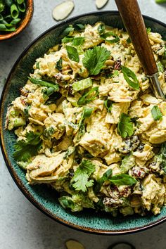 a bowl filled with chicken salad next to other bowls