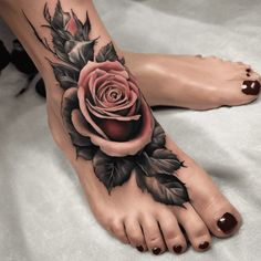 a woman's foot with a rose and leaves tattoo on the bottom of it