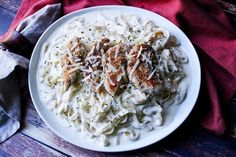 a white plate topped with pasta covered in cheese