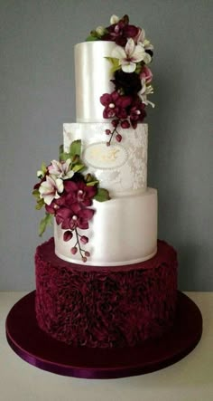 a three tiered wedding cake with flowers on top