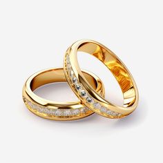 two gold wedding rings with diamonds on the inside and outside, set against a white background