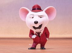 a cartoon mouse wearing a red suit and hat, standing in front of a wall