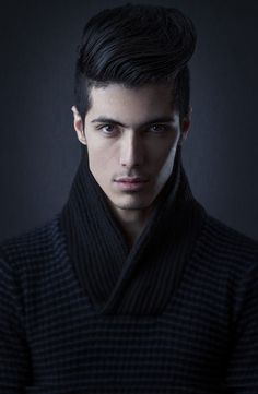 a man in a black coat is looking at the camera with an intense look on his face