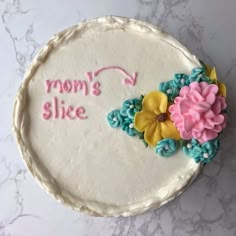 there is a cake that says mom's slice with flowers on the bottom and pink, blue, yellow and green icing