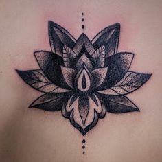 a black and white lotus flower tattoo on the back of a woman's chest