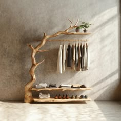 a wooden shelf with clothes and shoes on it in front of a wall mounted tree