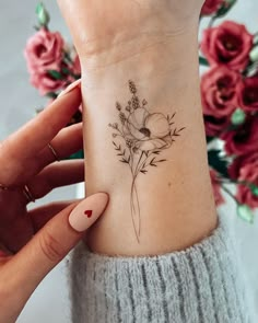 a woman's wrist with a flower tattoo on it