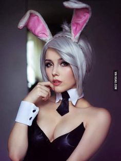 a woman with grey hair wearing bunny ears and a black dress is posing for the camera