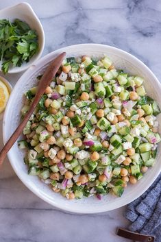 a white bowl filled with cucumber and chickpeas salad