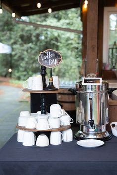 white china coffee cups on tiered stand by rustic bar Coffee Bar Display Wedding, Coffee Hot Chocolate Bar Wedding, Tea And Coffee Station Wedding, Party Coffee Station, Wedding Coffee Station, Coffee Bar At Wedding, Coffee Bar Wedding Reception, Hot Cocoa Bar Wedding, Coffee Station Wedding