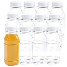 six plastic bottles with white caps are lined up next to each other on a white background