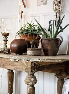 a table topped with potted plants and candles