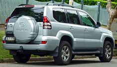 a silver suv is parked on the side of the road