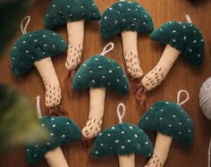 several green mushrooms are hanging from string on a table