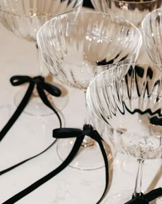 several wine glasses are lined up on the table with black ribbon around them and one is empty