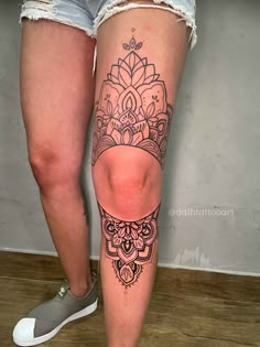 a woman's leg with a tattoo on it, and her legs are shown