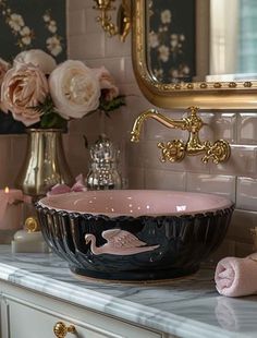 a bathroom sink sitting on top of a counter next to a vase with flowers in it