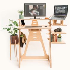 a laptop computer sitting on top of a wooden desk next to a monitor and keyboard