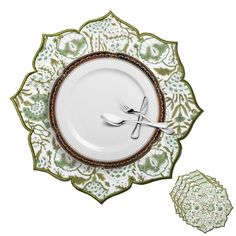 a white plate topped with a fork and knife next to a green flowered design