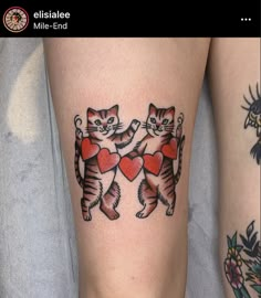 two cats with hearts on their legs, one is holding the other's arm