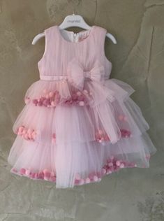 Beautiful European Dress with pom poms details. Back zipper and ties. Front bow with rhinestones. Pink Bow Dress For Dress-up, Pink Elegant Tutu Dress For Festive Occasions, Elegant Pink Tutu Dress For Festive Occasions, Festive Pink Ruffled Tutu Dress, Elegant Pink Festive Tutu Dress, Festive Sleeveless Dress With Ruffles, Party Tutu Dress With Pink Bow, Ruffled Dresses For Party Season Celebration, Sleeveless Tulle Dress For Celebration