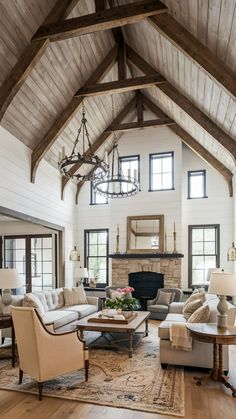 a living room filled with lots of furniture and a chandelier hanging from the ceiling