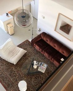 an overhead view of a living room with couches and coffee table in the middle