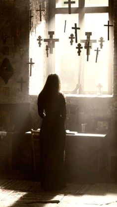 a woman standing in front of a cross window