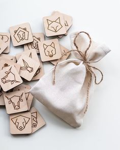 small wooden tags with animals on them and a drawstring bag next to them