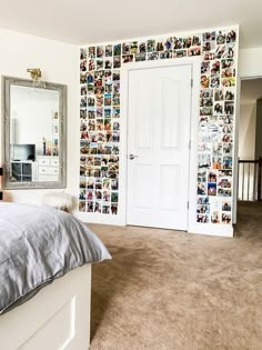 a bedroom with pictures on the wall and a bed in front of a large mirror