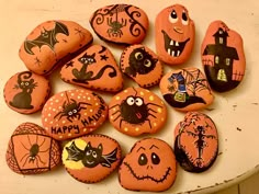 many decorated rocks are sitting on a table with pumpkins and bats painted on them