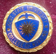 a blue and gold lapel badge on a red velvet surface with the words, state university college