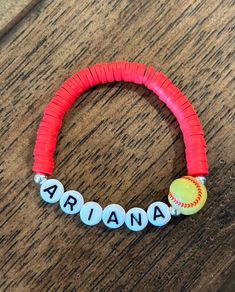 a red bracelet with white letters and a baseball ball on it that says ariaa