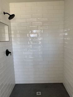 a white tiled shower with black grout