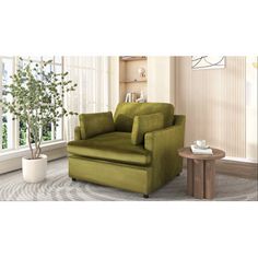 a green chair sitting in front of a window next to a table with a potted plant