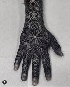 a person's hand with black and white designs on it