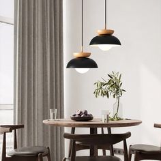 a dining table with four chairs and two hanging lights