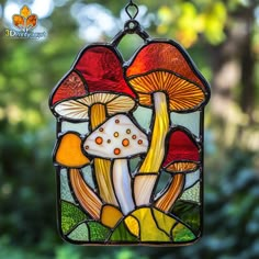 a stained glass window with mushrooms in the center and leaves on the outside, hanging from a chain