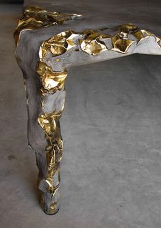 a gold and silver bench on concrete floor