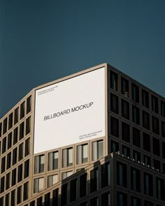 a billboard on the side of a building in front of a dark blue cloudless sky