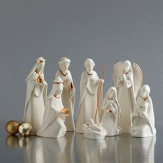 a group of white figurines sitting next to each other on a silver surface