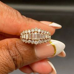 a woman's hand holding a ring with three rows of diamonds on top of it