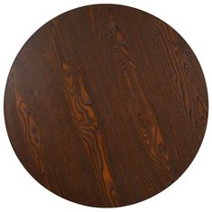 a round wooden table top with dark wood grains